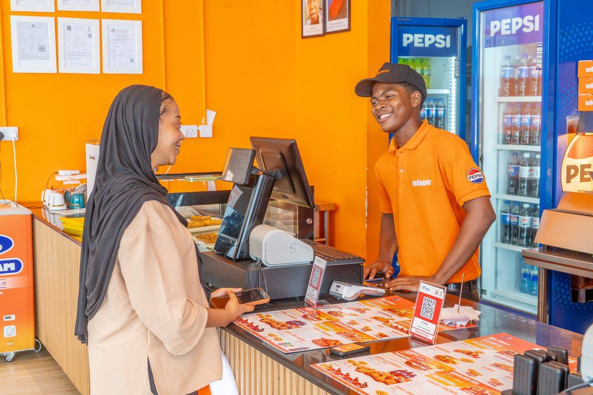 A happy customer collecting their order at the Kookoos counter
